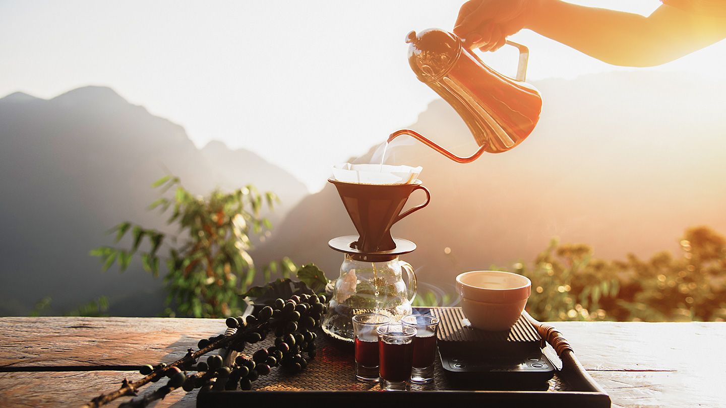 A steaming cup of coffee on a rustic wooden table